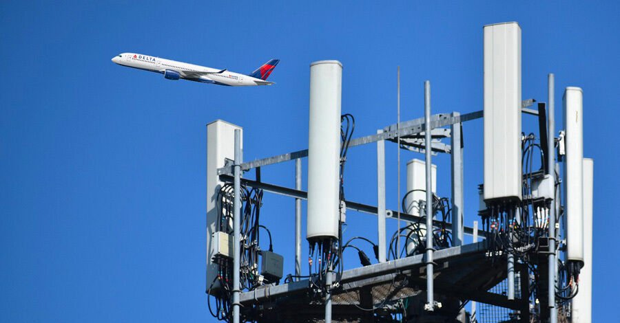 Antena 5G en primer plano y en el fondo un avión volando
