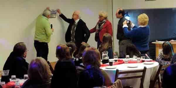  Ignacio Rey se descubre una placa de bronce fijada en la pared de la entrada del salón de eventos,