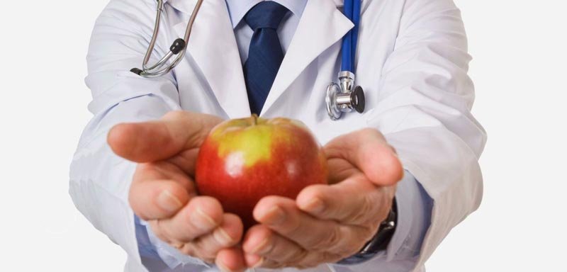 imagen de un medico sosteniendo una manzana